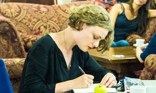 Student writing in cafe
