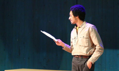 Man reading a script on stage
